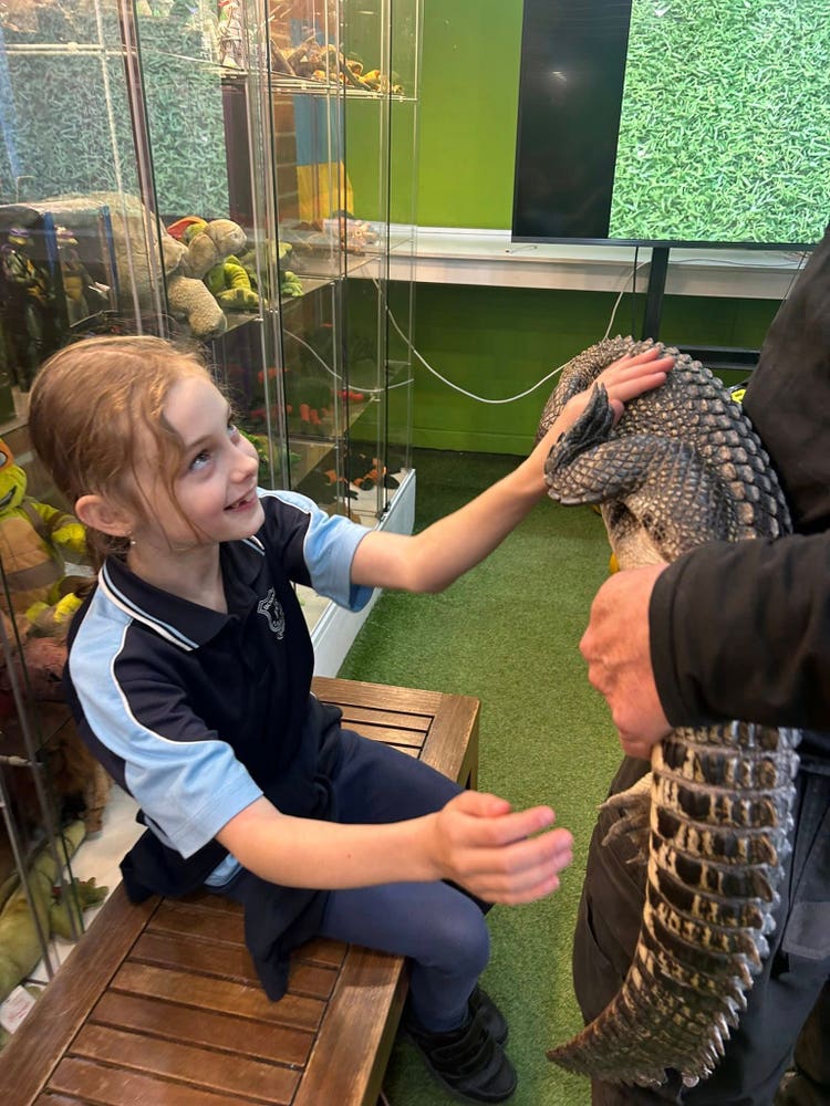 May be an image of 2 people and crocodile